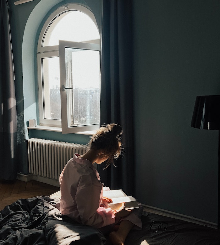 Woman reading on her bed